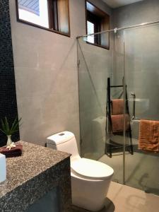 Un baño con inodoro y ducha de cristal. en Baan Tai Tara 3, en Ban Tai