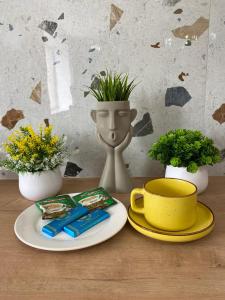 une table avec une assiette de nourriture, une tasse et des fleurs dans l'établissement Terracotta & Rooms комфортная студия для отдыха, à Uralsk