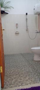 La salle de bains est pourvue de toilettes et de carrelage. dans l'établissement FARILA LODGE, à Ende