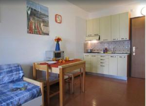 uma sala de estar com uma mesa e uma cozinha em Seafront building in a great location - Beahost em Bibione