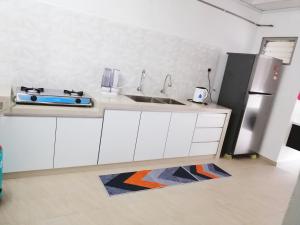 a kitchen with a sink and a refrigerator at Destiny Homestay in Sungai Petani