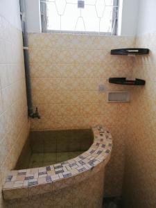 y baño con ducha y bañera de azulejos. en Destiny Homestay, en Sungai Petani