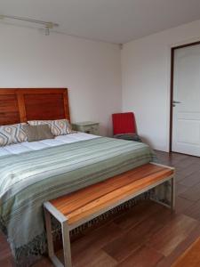 a bedroom with a wooden bed with a wooden bench at Casa Glaciar Patagonia in El Calafate