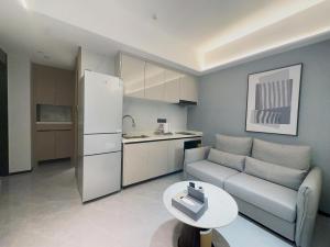 uma sala de estar com um sofá, uma mesa e uma cozinha em Canopy Executive Apartments - Liuxian Cave Headquarters em Shenzhen