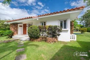 una pequeña casa blanca con un patio verde en The Dream of Playa Coronado en Playa Coronado