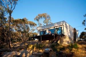 a house with a glass facade in a forest at Harmony in Hepburn Springs