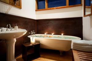 bagno con vasca, lavandino e candele di Hepburn View a Hepburn Springs