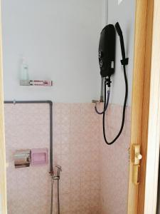 baño con ducha y secador de pelo en la pared en Destiny Homestay, en Sungai Petani