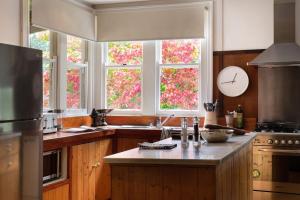 a kitchen with windows and a clock on the wall at Hepburn View in Hepburn Springs