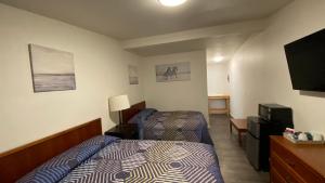 Schlafzimmer mit einem Bett und einem Flachbild-TV in der Unterkunft Golden Kent Motel in Kent
