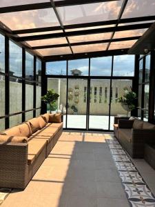 a conservatory with couches and windows in a building at 17 Riada Villa in San Juan