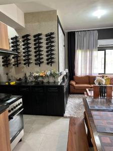 a kitchen with black cabinets and a living room at 17 Riada Villa in San Juan