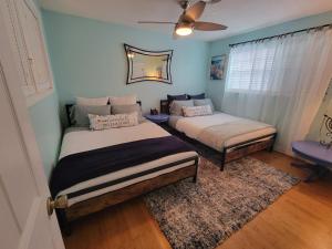 a bedroom with two beds and a mirror on the wall at Beach & Surf Hacienda on Hutchinson Island in Fort Pierce