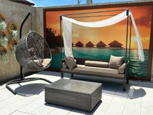 a swing and a chair on a patio at 17 Riada Villa in San Juan