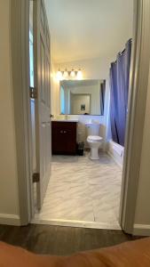 een badkamer met een toilet, een wastafel en een spiegel bij Golden Kent Motel in Kent