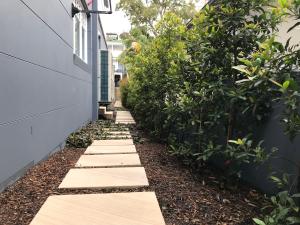 a walkway in a garden next to a building at Balmoral Salt in Sydney