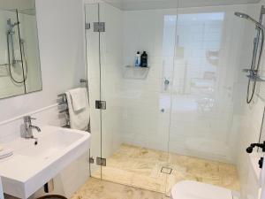 a white bathroom with a sink and a shower at Balmoral Salt in Sydney