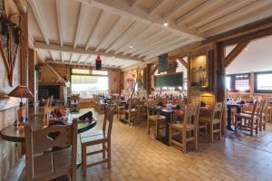 a dining room with tables and chairs in a restaurant at Logis Le Pont de Champ in Beaucroissant
