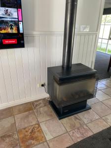 a wood stove in a room with a tv at Creek Cottage Bed and Breakfast Traralgon in Traralgon