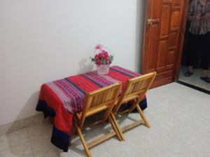a table with two chairs and a potted plant on it at Ha Giang Yolo House and Loop Tours in Ha Giang