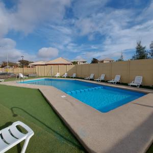 uma piscina com espreguiçadeiras num quintal em Acogedor departamento en Caldera, Bahía Inglesa, con Aire Acondicionado em Caldera