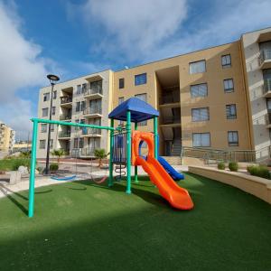 un parque infantil frente a un edificio de apartamentos en Acogedor departamento en Caldera, Bahía Inglesa, con Aire Acondicionado, en Caldera