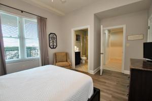 ein Schlafzimmer mit einem Bett und einem Stuhl sowie ein Badezimmer in der Unterkunft Wharf 812 in Orange Beach