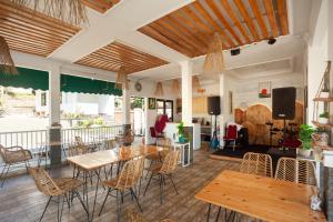 a dining room with wooden tables and chairs at Urbanview Resort Syariah Khansa Cisarua Puncak by RedDoorz in Tagalbato