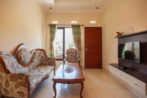 a living room with a couch and a tv at Urbanview Resort Syariah Khansa Cisarua Puncak by RedDoorz in Tagalbato