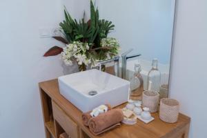 a bathroom sink on a wooden table with a mirror at The Gili Beach Resort in Gili Trawangan