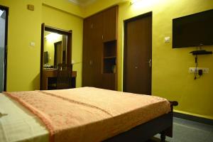 a bedroom with a bed and a flat screen tv at Hotel Siesta De Goa in Varca
