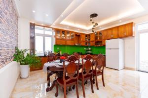 kuchnia ze stołem, krzesłami i lodówką w obiekcie Palm Villa 7 w mieście Vung Tau