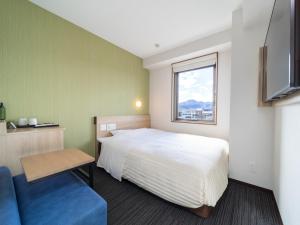 1 dormitorio con 1 cama y 1 sofá azul en Super Hotel Yahaba Station East Exit, en Yahaba