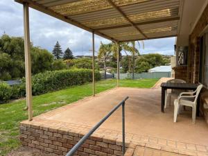 a covered patio with a table and a chair at Eos 2 in Esperance
