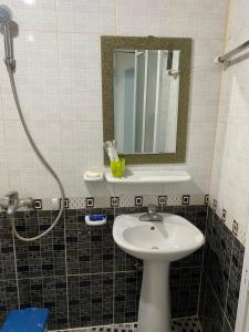 bagno con lavandino e specchio di Nhà nghỉ Hưng Thơm a Cat Ba