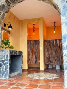 an entrance to a house with a stone fireplace at Casa Jasmin Bed & Breakfast in Troncones