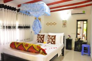 a bedroom with a bed with a blue umbrella at Another World Hostel Sigiriya in Sigiriya