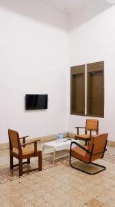 Jomblang的住宿－Hotel Candi Baru，一间设有三把椅子、一张桌子和一台电视的房间