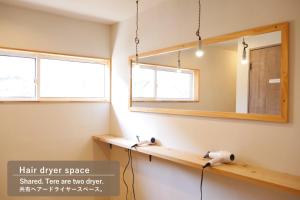 a bathroom with a mirror and two lights at Lodge Free Run in Otari