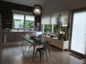 a kitchen with a table and chairs and windows at La Douc'Heure in Doucier