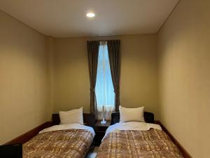 a room with two beds and a window at Pension Puutaro in Zaō Onsen +142 photos