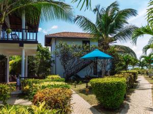 un complejo con una escalera y una sombrilla azul en Ananthaya Beach, en Tangalle