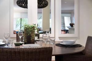 a wooden table with glasses and plates on it at Lake Daylesford Lodge 5 in Daylesford