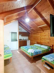 una camera con due letti e una tv di TONEDA Seaside Bungalows a Dhërmi