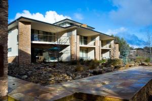 a house with a stone pathway in front of it at Lake Daylesford Lodge 5 in Daylesford