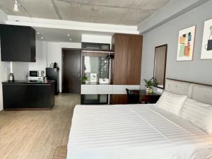 Cet appartement comprend une chambre avec un grand lit blanc et une cuisine. dans l'établissement Kem Apart 01, à Hanoï