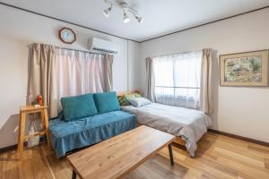 a bedroom with a bed and a couch and a window at My Retreat Osaka in Osaka