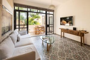 een woonkamer met een bank en een tafel bij Rustic Charm in Tel Aviv's Center by Sea N' Rent in Tel Aviv