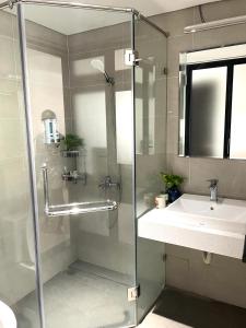 La salle de bains est pourvue d'une douche et d'un lavabo. dans l'établissement Kem Apart 01, à Hanoï