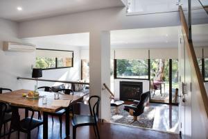 a dining room with a table and chairs and a fireplace at Lake Daylesford Lodge 6 in Daylesford